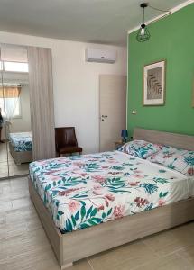 1 Schlafzimmer mit einem Bett mit Blumendecke in der Unterkunft La casa sotto il Fortino in SantʼAntìoco