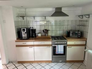 a kitchen with a stove and a microwave at Hexenhäuschen Wankendorf in Wankendorf