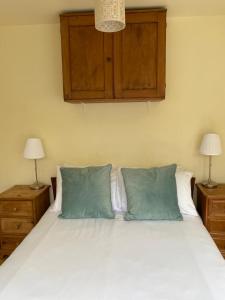 a bedroom with a bed with two pillows and two lamps at Lyme Clifftop Hideaway in Lyme Regis
