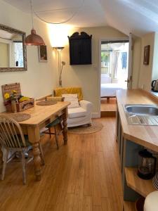 Lyme Clifftop Hideaway في ليم ريجيس: مطبخ وغرفة معيشة مع طاولة وأريكة