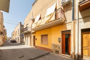 un edificio amarillo al lado de una calle en Casa Chiara, en SantʼAntìoco