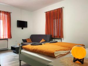 a bedroom with a bed with an orange blanket at Soba za goste Kraljica 4 in Kupres
