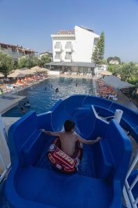 a man riding a water slide at a pool at Side Sunset Hotel in Side