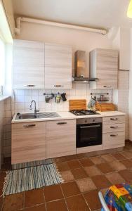 una cucina con armadi in legno e lavandino di La Pinetina ad Ancona