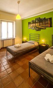 een slaapkamer met 2 bedden en een groene muur bij La Pinetina in Ancona