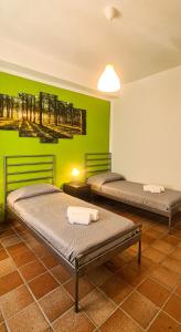 2 letti in una camera con parete verde di La Pinetina ad Ancona