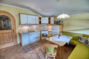 uma cozinha com uma mesa e um sofá verde em Appartments Geisler em Achenkirch