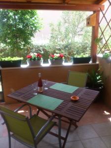 uma mesa com 2 cadeiras e uma garrafa de vinho num pátio em Apartment Ivan em Trogir