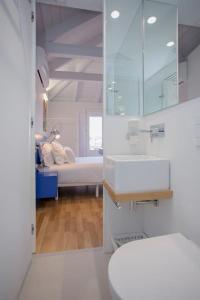 a white bathroom with a sink and a bed at Downtown Cosy Suite VI in Porto
