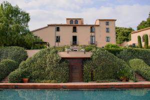 a house with a pool in front of a building at Can Mora de Dalt in Sant Vicenç de Montalt