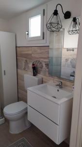 ein Badezimmer mit einem weißen WC und einem Waschbecken in der Unterkunft La casa sotto il Fortino in SantʼAntìoco