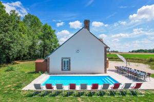 a house with a swimming pool and chairs at So Villa Les Houx 45 - Heated pool - Soccer - 2h from Paris - 30 beds in Triguères