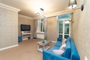 a living room with a blue couch and a tv at Maner hotel in Odesa