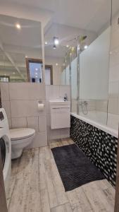 e bagno con servizi igienici, vasca e lavandino. di LUXURY SILVER APARTMENT by Marta a Radom