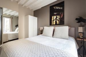 um quarto com uma cama branca e um cartaz na parede em Room in Apartment - Cosy place in the Hear of Paris em Paris