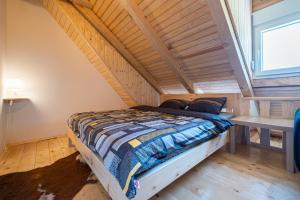 un letto in una stanza con soffitto in legno di Apartments CENTER OF THE WORLD a Žabljak