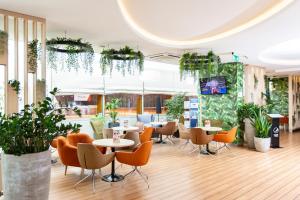 restauracja ze stołami, krzesłami i roślinami w obiekcie Hotel Bażantowo Sport w mieście Katowice
