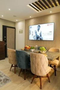 comedor con mesa, sillas y pantalla en Luxurious apartment for rent, en Kafr al ‘Ilw