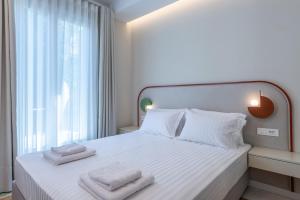 a bedroom with a white bed with towels on it at Casa Navarino by Immobilis in Nafplio