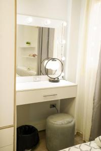 baño con tocador con espejo y taburete en Luxurious apartment for rent, en Kafr al ‘Ilw