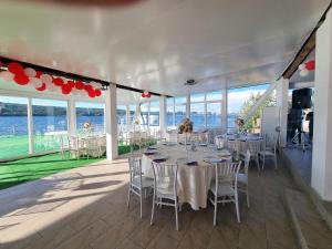 a banquet hall with tables and chairs with a view of the water at La Ponton AdaKale in Vrancea