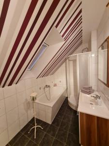 a bathroom with a bath tub and a sink at Ferienwohnung Warnitz in Blankenburg Oberuckersee