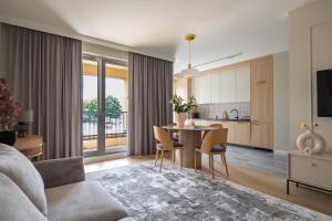 a living room with a table and a kitchen at Apartament Zoja II in Elblag