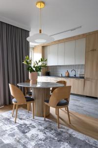 a kitchen with a table and two chairs and a counter at Apartament Zoja II in Elblag
