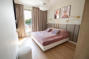 a bedroom with a bed and a large window at Apartament Zoja II in Elblag
