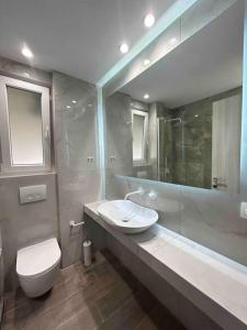a bathroom with a toilet and a sink and a mirror at 95sqm 7min Center 2bedroom Gas heating Marble Wc 2 SmartTv in Thessaloniki