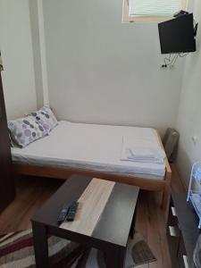 Cette petite chambre comprend un lit et une table. dans l'établissement Guest House Zoran, à Kragujevac