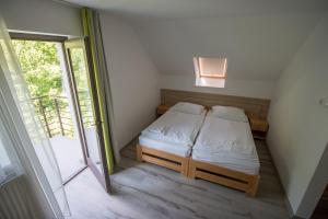 a small bedroom with a bed and a window at Diás Panzió in Orfű