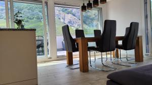 a dining room with a table and black chairs at Luxury Appartement de 130 m2 avec 3 chambres in Ardon