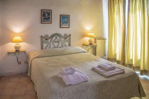 a bedroom with a bed with two towels on it at Hotel Sunset Green in Ischia