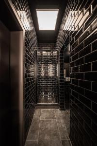Baño oscuro con pared de ladrillo y tragaluz en LOFT Design Studio 600m zur Messe/Lanxess en Colonia