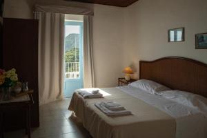 ein Schlafzimmer mit einem Bett und einem großen Fenster in der Unterkunft Hotel Sunset Green in Ischia