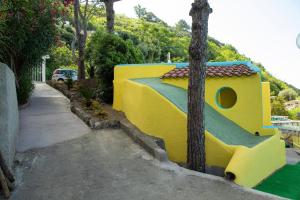 a house that is painted yellow and blue at Hotel Sunset Green in Ischia