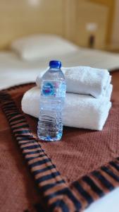 a bottle of water sitting on top of towels at Logis L'Abreuvoir in Héric