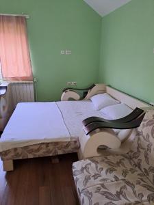 2 camas individuales en una habitación con paredes verdes en Guest House Zoran en Kragujevac