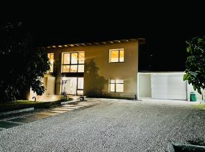 a large house with a garage at night at villa amarena, centralissima giardino e parcheggio in Angera