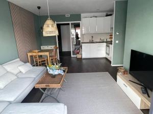 a living room with a white couch and a table at Appartement Feucht -Bhf 5 Min - Nähe Messe in Feucht