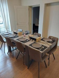 - une table dans une pièce entourée de chaises dans l'établissement Gite d'exception 13 couchages avec jacuzzi et sauna, à Châlons-en-Champagne