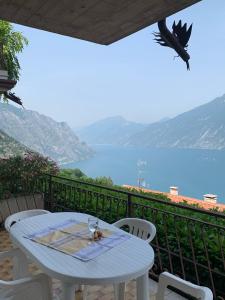 a table and chairs on a balcony with a view of the water at Casa Eulberg Marcania Balcone vista lago in Tremosine Sul Garda