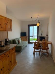 a kitchen and living room with a table and chairs at Casa Eulberg Marcania Balcone vista lago in Tremosine Sul Garda