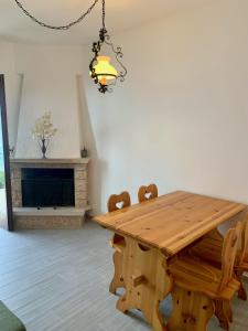 a dining room with a wooden table and a fireplace at Casa Eulberg Marcania Balcone vista lago in Tremosine Sul Garda