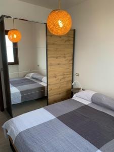 a bedroom with two beds and two mirrors at Casa Eulberg Marcania Balcone vista lago in Tremosine Sul Garda
