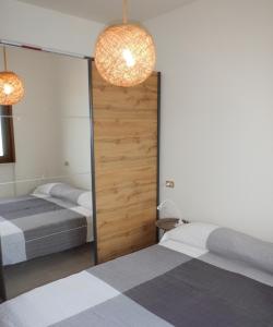 a bedroom with two beds and a sliding door at Casa Eulberg Marcania Balcone vista lago in Tremosine Sul Garda