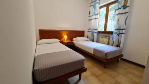 2 camas en una habitación pequeña con ventana en Casa Bellicini appartamento Balcony Lake View Park, en Tremosine Sul Garda