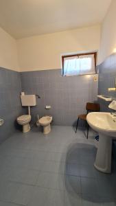 baño con 2 aseos y 2 lavabos y ventana en Casa Bellicini appartamento Balcony Lake View Park, en Tremosine Sul Garda