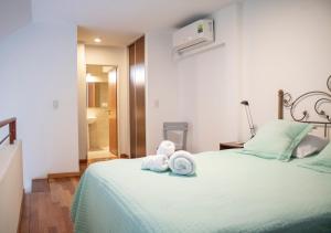 1 dormitorio con 1 cama con 2 toallas en Ayres de Saavedra - Dot Baires Shopping en Buenos Aires
